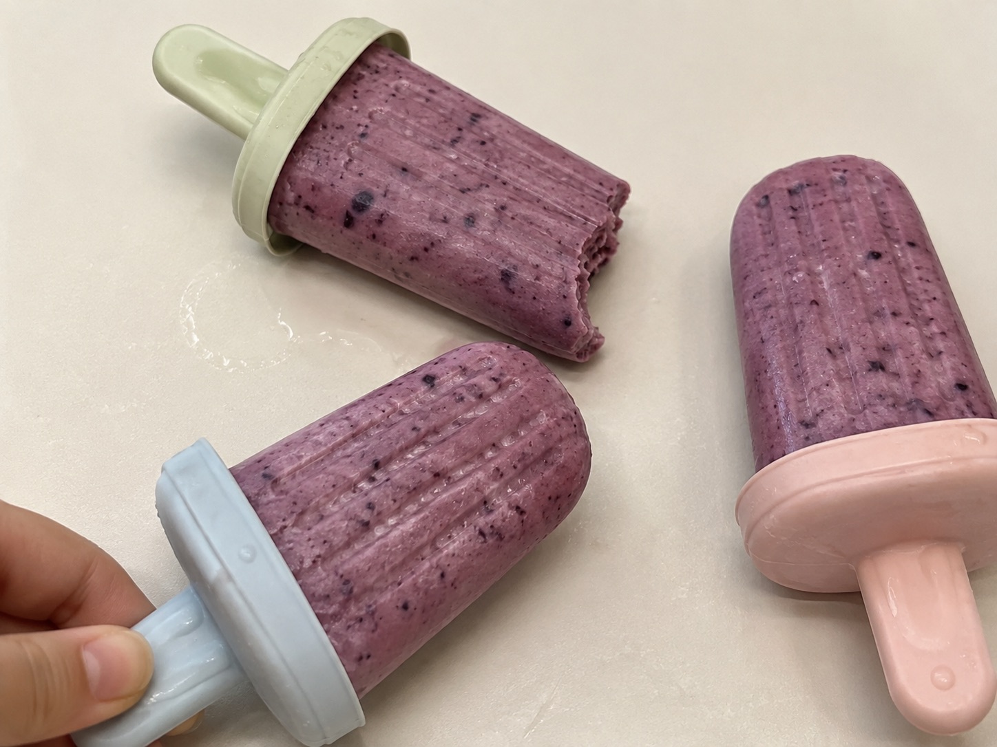 Zelfgemaakte paarse yoghurtijsjes met wilde blauwe bes